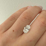 Diamond ring on a hand against a plain background