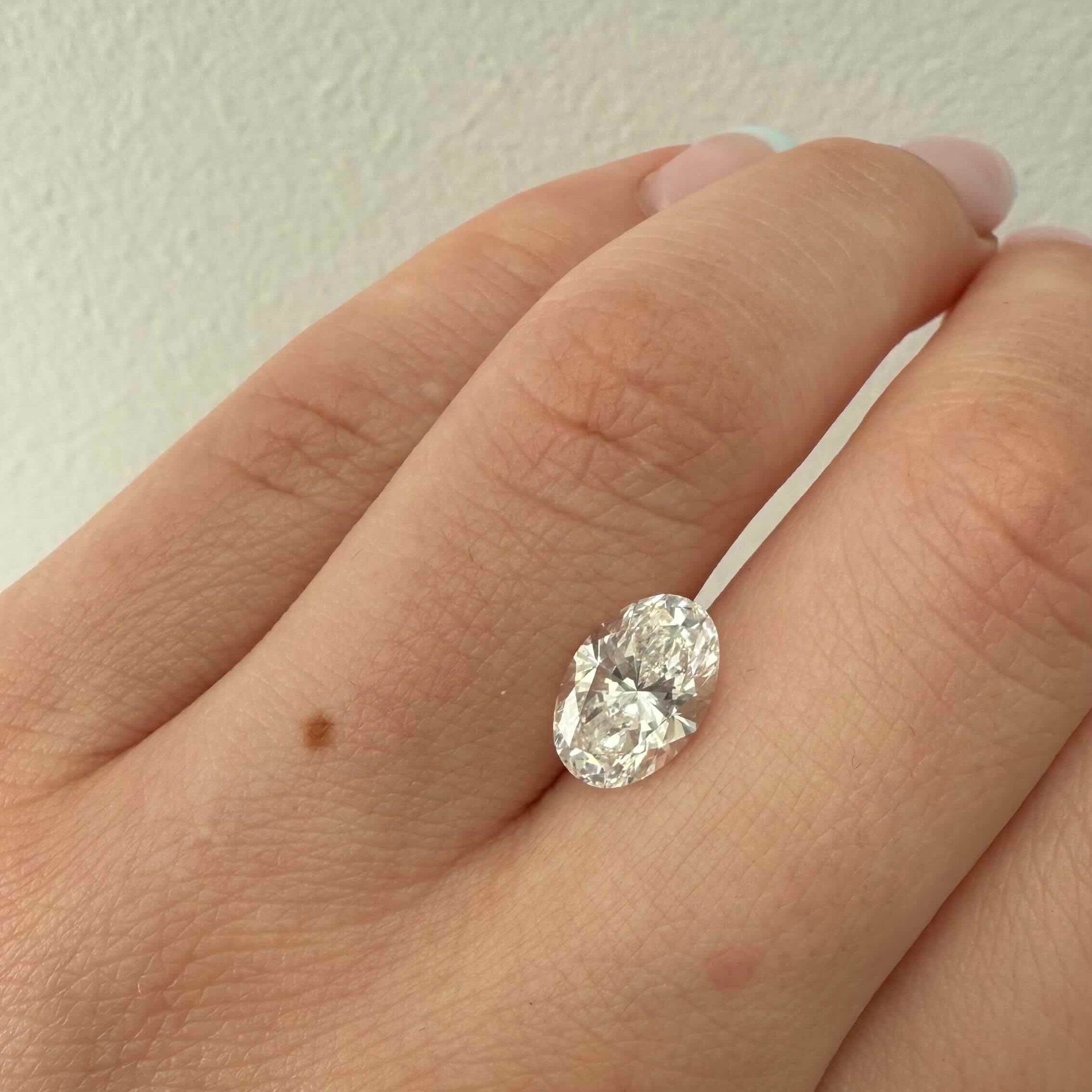 Diamond ring on a hand against a plain background